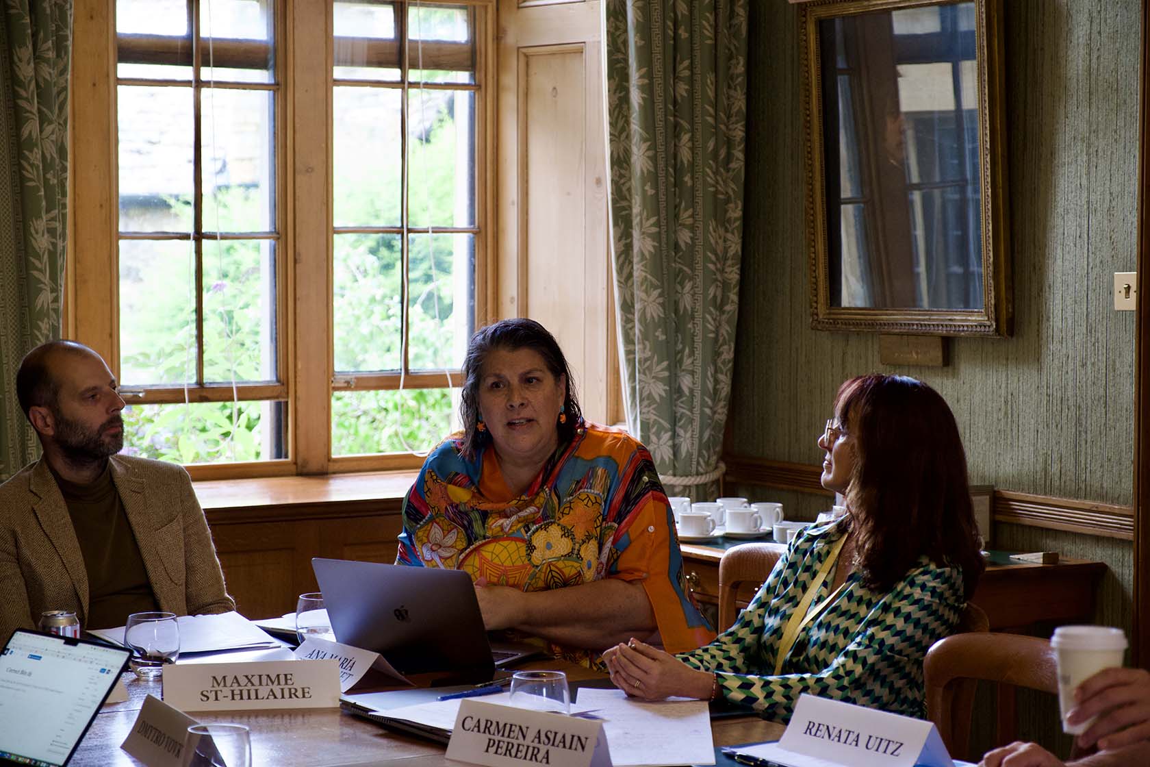 A delegate discusses her topic with other delegates at the table.